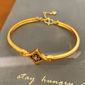 Detalle de brazalete floral chapado en oro con esmalte negro e incrustación de circón - Pulsera / Dorado Negro