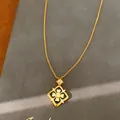 Detalle de primer plano de un collar de flores bañado en oro con esmalte negro y circonitas. - Collar de Corazón Calado / Dorado Negro