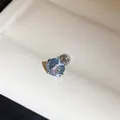 Close-up van een roestvrijstalen oorknopje met een lichtblauwe ronde gefacetteerde kristal - 6mm / Blauw en Wit