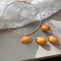 Detailansicht des gelben Harz-Oval-Schmucksets mit Halskette und passenden Ohrringen - Ohrringe Ring Choker / Gold-Gelb