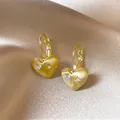 Gedetailleerd overzicht van 18k vergulde hart oorbellen met zirkonia op zijden achtergrond - Oorbakje / Goud