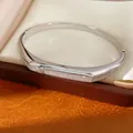 Detailed view of an elegant silver-tone zircon pavé oval bangle in a jewelry gift box - Silver