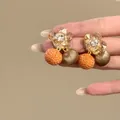 Detailopname van zirkoon bloemoorbellen met bungelende stoffen bollen - koffiekleur