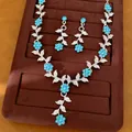 Exquisites Set aus blauem Blumen- und Blattschmuck auf braunem Samtständer präsentiert - Schmuckset (Halskette + Ohrringe) / Silber + Himmelblau