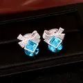 Gros plan sur les boucles d'oreilles nœud avec zircon bleu et pierres pavées. - Clip Argenté (HE35362) / Pack de 1 paire / Bleu