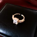 Gros plan d'une bague ouverte carrée en zircone plaquée or 18k sur boîte noire - Or