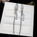 Gros plan de boucles d'oreilles à pampilles en cristal avec chaînes argentées - Boucles d'Oreilles Pendantes à Glands (Tige en Argent) / Transparent