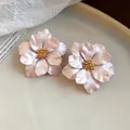 Nahaufnahme der rosa Blumen-Ohrstecker mit eleganten goldenen Staubblatt-Mitten - Rosa