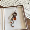 Nahaufnahme einer Vintage-Halskette mit Holzring und bernsteinfarbener Harz-Wassertropfen - Feder-Muschel-Ring-Stil (4项链-咖色) / Kaffeebraun