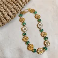 Vintage court style necklace featuring gold flower charms and green beads detail on texture - Chain Only / Gold-Green