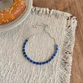Gros plan sur un bracelet ajustable en argent serti de zircons bleus étincelants en goutte - Bleu