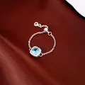 Détail d'une bague chaîne réglable avec zircon bleu carré sur fond de soie rouge - Style Réglable Zirconia Carré Bleu (HR4013) / Argent-Bleu