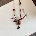 Close-up of a handmade wooden bear pendant necklace with brown suede cord and coffee bean beads. - Teddy Bear