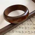 Vue détaillée d'un bracelet jonc rond en bois marron vintage sur fond de calligraphie - 3# Style Plein et Arrondi (Café)