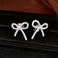 Macro detail of silver bow clip-on earrings with pave-set shimmering cubic zirconia stones - Ear Cuff (Pair) / Silver