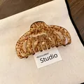Nahaufnahme einer Haarklammer mit Leopardenmuster aus Acryl auf Leinwandhintergrund - Braun Leopard Verschmiert