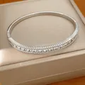 Hochwertige Nahaufnahme eines silberfarbenen Armreifs mit Zirkonia-Besatz auf Schmuckbox - Silber