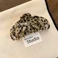 Detailansicht einer Haarklammer aus Acryl mit grauem Leopardensternmuster auf Canvas - Beige und Schwarz Verschmiertes Sternmuster