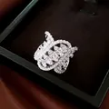 Macro view of a luxury geometric twisted oval ring set with sparkling zircons in a box. - Silver