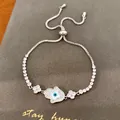 Κοντινό πλάνο κομψού βραχιολιού Hamsa 18k επιχρυσωμένο με ζιργκόν και λευκό φίλντισι - Στυλ Χέρι της Φάτιμα Τριφύλλι / Ασημί