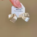 Dettaglio di orecchini a lobo minimalisti in argento 925 spazzolato a forma di C su carta - Stile spazzolato a forma di C / Argento