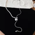Gedetailleerde weergave van een asymmetrische zilveren ketting met parels en hart. - Harthanger / Zilver