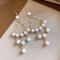 Elegant macro shot of French light luxury pearl fringe earrings with golden ear hooks - Round Tassel Ear Hook Style / Gold with White