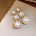 Close-up of French luxury triple pearl drop earrings with elegant gold-tone framing - 925 Silver Post Style / Gold with White
