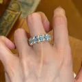 Detailaufnahme eines eleganten zweireihigen Perlenrings mit blauen Steinen am Finger - Silber Blau Stil