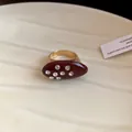 Close-up of retro burgundy enamel oval ring with sparkling inlaid crystals in gold finish - Red - Small