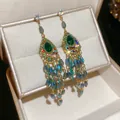Detailed macro view of vintage earrings featuring green teardrop stones and blue tassels - Emerald Water Drop Beaded Tassel (39#) / Silver Earring Post Style / Green
