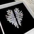 Gros plan macro détaillé de boucles d'oreilles en zircone étincelantes en boîte. - Style Géométrique Aile / Tige de boucle d'oreille en acier / Argent