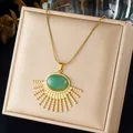Detailopname van een vergulde waaiervormige hanger met een ovale groene harssteen hanger - Waaiervormige Groene Edelsteen Ketting (N4590)