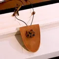 Gros plan détaillé de l'ornement en résine de chat sur un collier porte-lunettes en daim - Style de Chat / Marron