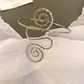 Detailansicht eines trendigen silbernen Spiralarmreifens mit Hammerschlag-Metalltextur - Armspange / Silber