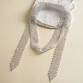 Close-up of a luxury white rhinestone woven tie necklace on a textured stone prop - White AB