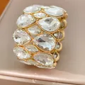 Makroaufnahme eines elastischen Armbands mit zweilagigen, klaren Kristallen in Tropfenform - Gold