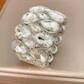 Nahaufnahme eines breiten elastischen Armbands mit glitzernden Tropfenkristallen - Silber