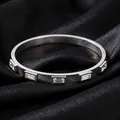 Gros plan sur un bracelet en acier argenté poli orné de zircons rectangulaires - Bracelet à cinq strass blancs dimensionnels (53-B-1)