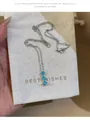 Détail d'un collier en argent avec pendentif fleur en zircon bleu sur pochette cadeau. - Pendentif Fleur / Argent & Bleu