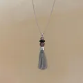 Detailweergave van een roestvrijstalen ketting met kwastje, kralen en kettingen. - Ketting / Zilver-Grijs