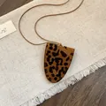 Detailopname van vintage luipaardprint brilclip halsketting op stoffen achtergrond - Luipaard Hanger / Bruin