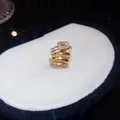 Nahaufnahme eines eleganten Gold-Zirkonia-Ohrclips mit funkelnden Steinen - Einzelner Ohrclip / Gold