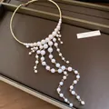 Detail view of a French palace style pearl choker featuring an elegant tassel design. - Gold with White Pearl