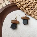 Vue macro détaillée de boucles d'oreilles ethniques en bois aux textures naturelles - Crochets de boucles d'oreilles / Café, Noir