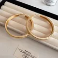 Detailed view of oversized gold hoop earrings with textured finish on jewelry tray - Wrinkled (Large) / Gold