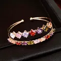 Primo piano dell'elegante bracciale rigido in oro a due strati con zirconi quadrati colorati - Oro-Multicolore