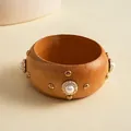 Gedetailleerd zicht op een vintage etnische houten armband met goudkleurige studs - Klinknagel Parel Stijl