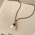 Macro detail of elephant pendant with malachite and yellow beads on black cord. - Elephant