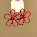 Primo piano che mostra la finitura rossa lucida e i pois bianchi sugli orecchini a fiore - Stile Perno in Argento / Rosso